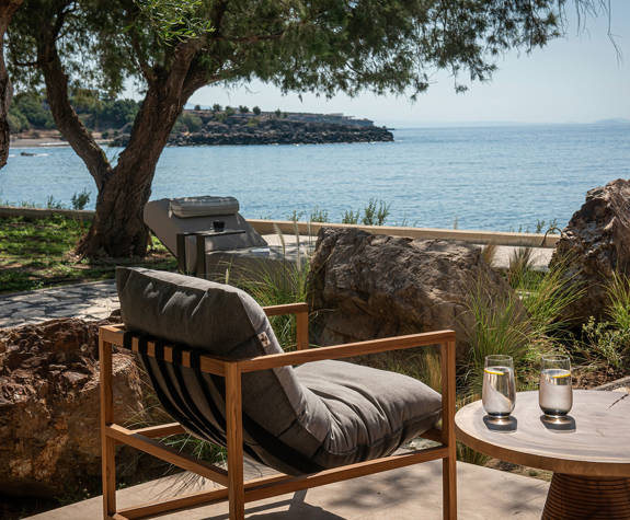 The Echo Of The Sea Beachfront Villa terrace chair and the small round table with two glasses on it