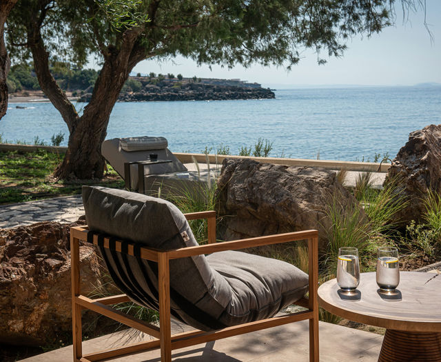The Echo Of The Sea Beachfront Villa terrace chair and the small round table with two glasses on it