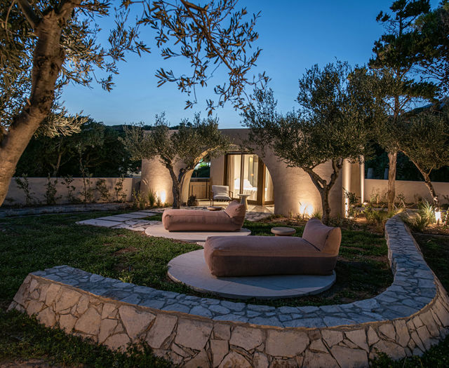 The Echo Of The Sea Beachfront Villa garden with sunbeds lit up at dusk