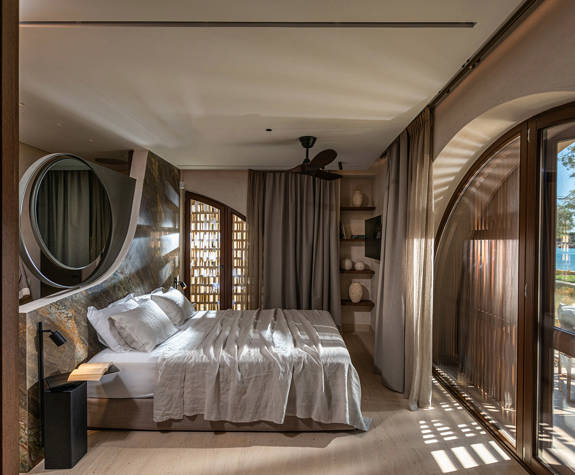 The Echo Of The Sea Beachfront Villa decorated bedroom with double bed and terrace view