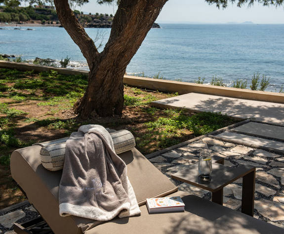 The Echo Of The Sea Beachfront Villa sunbed with a small stool with a drink on it and sea view